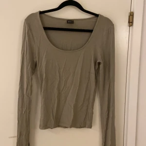 Grön långärmad topp från Gina Tricot - Grön urringad tröja med utsvängda armar. Jätte fint skick bara lite skrynklig😊