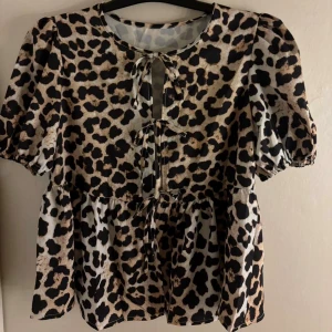 Leopardmönstrad blus med knyt - Säljer en blus med leopardmönster i beige och svart. Aldrig använd!! Finns ingen lapp men tröjan är från shein. Passar mig som är i storlek XS/S 