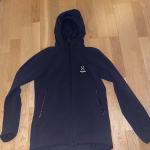 Haglöfs vindjacka - Knappast använd, 9/10 skick, det finns en liten defekt i vänstra fickan, å därför priset men man märker inte alls defekten den är inte synlig och man känner inte av den.