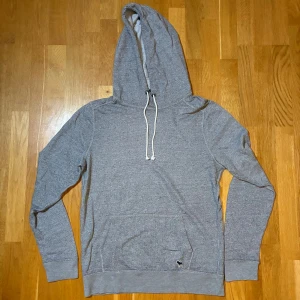 Grå hoodie Abercrombie & Fitch M - Snygg grå hoodie från Abercrombie & Fitch i storlek M. Tillverkad i mjuk bomullsmix med ribbade muddar och lång ärm. Perfekt för chill dagar och enkel att matcha med jeans. Använd men bra skick!
