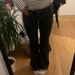 Svarta bootcut jeans  - Snygga svarta jeans med bootcut passform och klassiska orange sömmar. Jeansen är lite svart/ gråa. Dom är storlek 34 men skulle säga att dom även passar 36