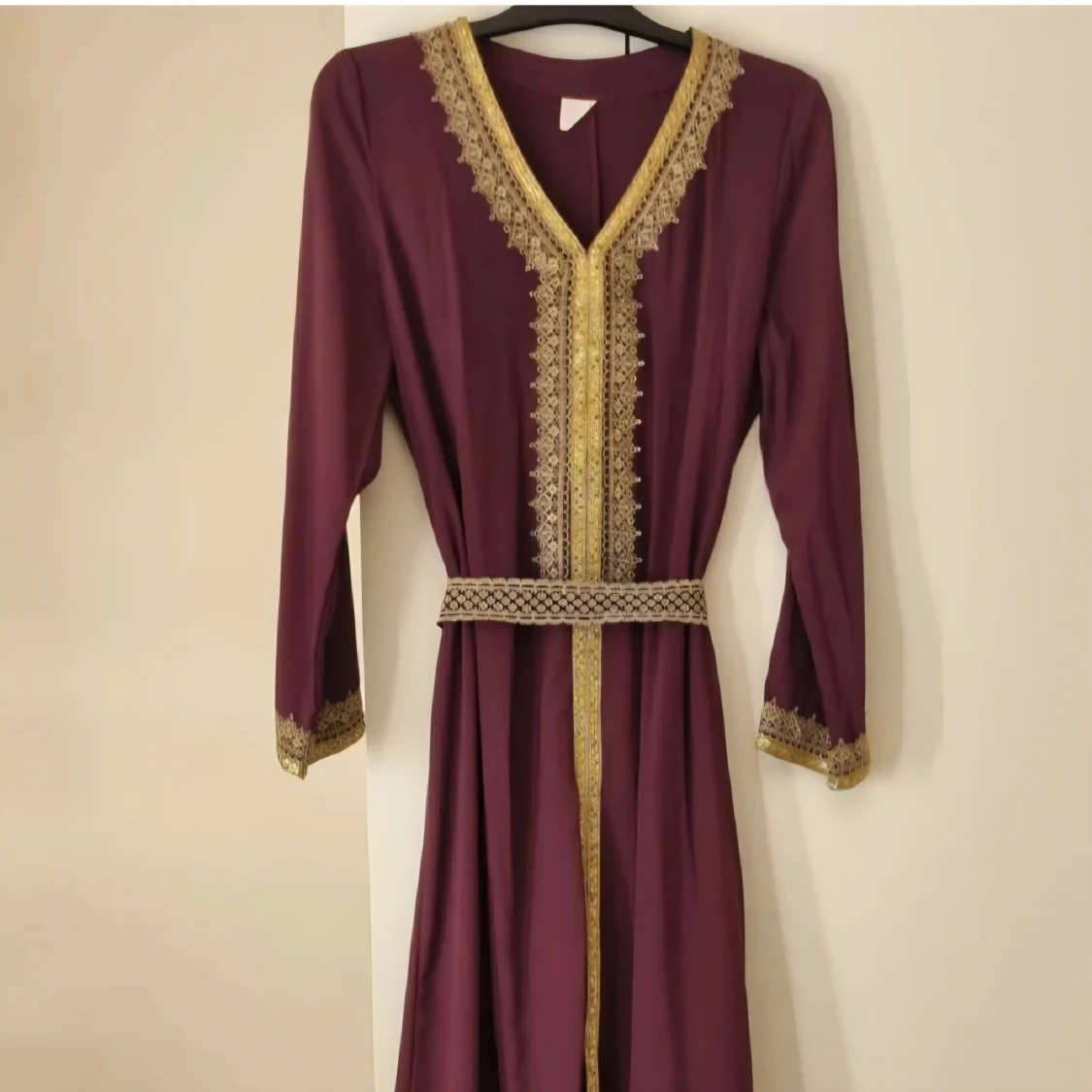 Lång vinröd klänning med gulddetaljer