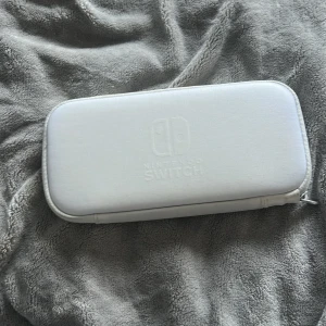 Nintendo Switch Bärväska - Snygg och praktisk originalväska för Nintendo Switch. Väskan är i mycket gott skick, med plats för konsol, spel och tillbehör. Perfekt för att skydda och ta med din Switch på resan. Inga synliga defekter eller slitage.