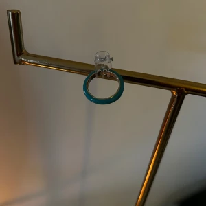 Turkos ring i enkel design - Säljer en stilren ring i turkos färg med rund form. Ringen har en slät yta och är perfekt för dig som gillar minimalistiska smycken med färg. Passar att bära ensam eller att kombinera med andra ringar för en personlig stil.