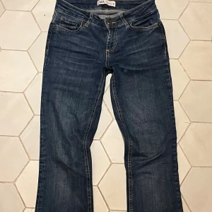 Blå bootcut jeans från Zara - Mörkblå Lågmidjade bootcut jeans från Zara, använda en del men utan defekter! Har inte fler bilder på då de blivit för små 