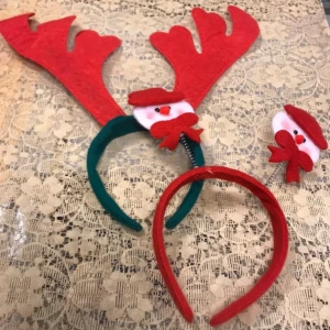 Juldiadem med renhorn och snögubbe - Roliga juldiadem med stora röda renhorn och en söt snögubbe i filt på ena sidan. Medföljer även ett rött diadem med snögubbe. Perfekt för julfirandet och att sticka ut på festen. Materialet är mjuk filt i rött, grönt och vitt.