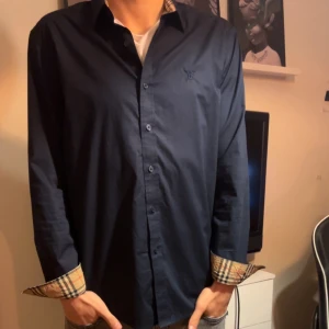 Burberry skjorta - Skick: 9/10. Modellen är ca 180cm. Pris kan diskuteras vid snabb affär. Storlek L men passar M och även S.