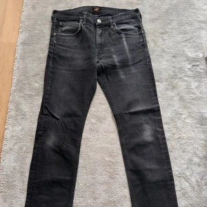 Svarta jeans från Lee straight fit w31 L30 - Snygga svarta jeans från Lee med klassisk femficksdesign och silverfärgade knappar. Jeansen har en rak passform och subtila slitningar för en cool look. Materialet är mjukt denim och midjan är normal. Perfekta för dig som gillar stilrena och tidlösa jeans.