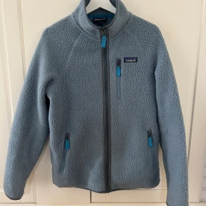 Patagonia fleece - Patagonia fleece en så snygg och unik färg🩵🩵älskar denna!! Storlek M. Den har ett litet hål och slitage på under armen men inget man tänker på (se sista bilden)
