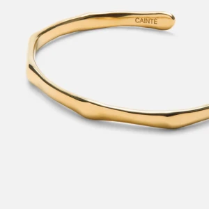 Guldfärgat armband från Cainte - Stilrent armband från Cainte i 14k guldplätering. Armbandet har en unik, oregelbunden form som ger en modern och cool känsla. Perfekt accessoar för att lyfta din outfit med en touch av lyx. ALDIRG använd. Passade ej mig. HELT NY. Orginal förpackning och allt finns. 