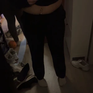 Svarta kostymbyxor med fickor på rumpan  - Säljer ett par svarta kostymbyxor med normal passform och rak siluett. Byxorna har en enkel och clean look,   Resår i midjan för extra komfort. Passar dig som gillar en avslappnad stil.