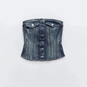 Jeanskorsett med knappar  - Säljer en snygg jeans korsett-tubtopp i mörkblå denim med silverfärgade knappar framtill och rå kant nertill💕