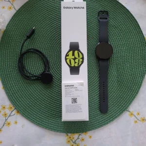 Samsung Galaxy Watch6 svart smartklocka - Samsung Galaxy Watch6 med rund svart urtavla och svart silikonarmband. Modern och stilren design, perfekt för dig som gillar teknik och vill ha koll på hälsa, träning och notiser direkt på handleden. Laddkabel och originalförpackning medföljer. Några små skrapar runtomkring men inga skador på skärmen och fungerar exakt som ny.