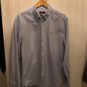 Ljusblå skjorta från Morris - Säljer en ljusblå Oxfordskjorta från Morris i storlek L. Sparsamt andvänd, inga synliga defekter. Säljer eftersom att jag har växt ur den. Nypris är uppemot 1200. Hör gärna av dig vid funderingar! 