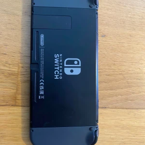 Nintendo Switch - Nintendo Switch i svart med original Joy-Con, dockningsstation och laddare. Konsolen ser ut att vara i gott skick med mindre tecken på normalt bruk. Perfekt för både handhållet och TV-spelande. Allt du behöver för att komma igång med spel direkt.
