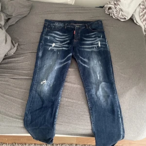 Mörkblå slitna jeans från Dsquared2 - Säljer ett par mörkblå jeans från Dsquared2. Strl 52 det motsvarar 32-34 men skulle säga de sitter ungefär som 33-34 i midjan. Väldigt fina och knappast använda, priset kan diskuteras vid snabb affär!