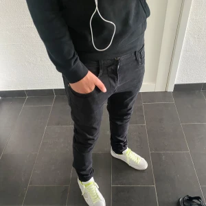 Replay jeans anbass - Säljer ett par svarta Replay Anbass jeans i storlek 31/32. Modellen har en slim passform med klassisk femficksdesign och dragkedjegylf. Snygg, stilren look som passar till sneakers och hoodie. Materialet är mjukt och följsamt för en bekväm känsla.