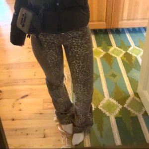 Leopardmönstrade jeans från Nelly - Säljer ett par snygga jeans från Nelly med leopardmönster i grå och beige toner. Byxorna har normal midja, klassisk femficksmodell och raka ben med lätt bootcut. Materialet är stretchigt för en bekväm passform. Perfekta för dig som vill sticka ut.