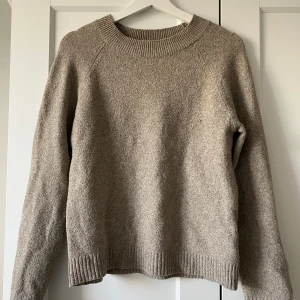 Beige stickad tröja från Vero Moda - Mysig beige stickad tröja från Vero Moda i storlek XS. Tröjan har rund hals, ribbade muddar vid hals, ärmslut och nederkant samt långärmad passform. Perfekt för att hålla sig varm under kyliga dagar och har en enkel, stilren look.