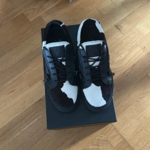 Giuseppe Zanotti sneakers med pälsdetaljer - Unika sneakers från Giuseppe Zanotti med svart och vit pälsimitation i coolt mönster. Dem är storlek 41 och är använda 2 gånger så dem är som nya. Skriv om ni har frågor! ❗️kan även tänka mig ett byta mot ett par Maison margiela❗️
