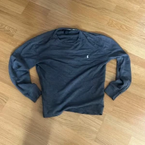 Grå långärmad tröja från Ralph Lauren - Snygg grå långärmad tröja från Polo Ralph Lauren i 100% bomull. Har en liten defekt vid kragen (bild 3). Skriv om du har fler frågor!