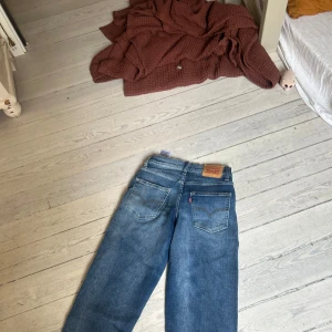 Levi's 501 blå jeans straight fit - Klassiska blå Levi's 501 jeans med raka ben och normal passform. Jeansen har fem fickor, synliga nitar och den ikoniska läderpatchen bak i midjan. Tillverkade i slitstarkt bomullsjeans med snygg tvättad look och röda Levi's-taggen på bakfickan. Skicka Järna pris förslag.ganska säker på att de är storlek w30 eller w32