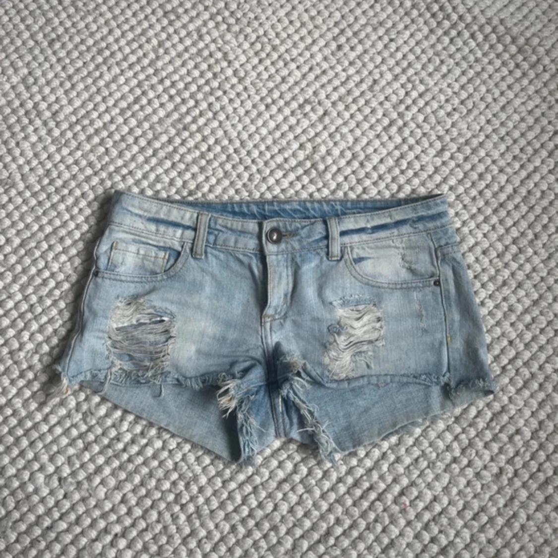 Ljusblå slitna jeansshorts