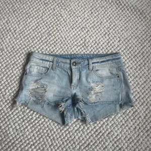 Ljusblå slitna jeansshorts - Fina lågmidjade jeansshorts 