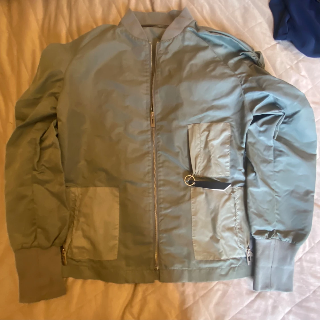 Ljusgrå bomberjacka med detaljer