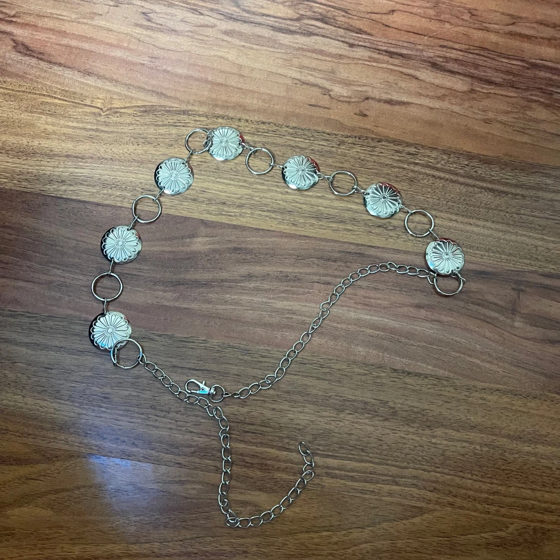 Silvrigt kedjebälte med blommor