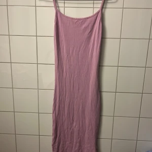 Rosa ribbad långklänning - Säljer en enkel och snygg rosa långklänning med smala axelband och ribbad struktur. Klänningen är figurnära och har en mjuk, stretchig känsla som gör den superbekväm. Den passar xs & s🫶🏽🫶🏽