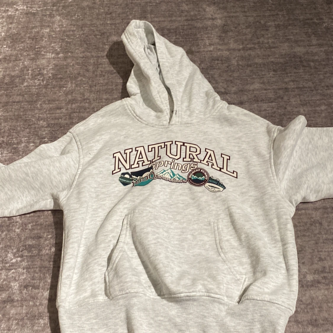 Ljusgrå hoodie från Divided med tryck