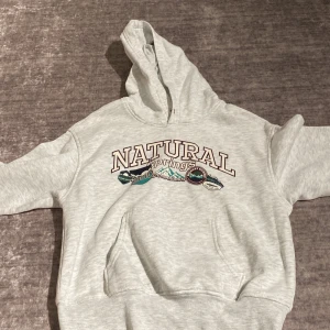 Ljusgrå hoodie från Divided med tryck - Ljusgrå hoodie från Divided med trycket 'NATURAL Springs' och coola naturmotiv på bröstet. Klassisk känguruficka framtill, mjuk insida och huva. Perfekt för chill dagar och snygg till jeans eller leggings.