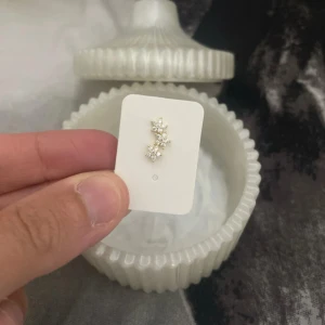 Guldiga örhängen med stjärnform/ rostfri och 18 k guldpläterad - Säljer ett helix  örhänge i guldton med gnistrande vita stenar formade som stjärnor.  Köpt i Turkiet! Helt ny! Perfekt för dig som gillar detaljer som sticker ut och vill ha något glittrigt i öronen. Snygg och trendig design som passar till många stilar.