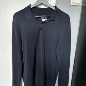 Mörkblå pikétröja  - Snygg mörkblå långärmad pikétröja från These glory days, volt. Storlek small och i grymt skick. Kontakta vid frågor!