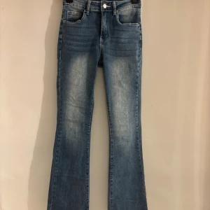 Blå bootcut jeans med broderade fickor - Snygga blå bootcut jeans med ljusa slitningar och broderade bakfickor. Midwasist!! Jätte sköna och sitter perfekt, de har bra stretch!