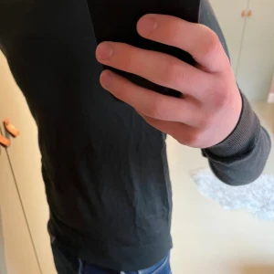 Mörkgrön stickad tröja från Uniqlo - Snygg mörkgrön stickad tröja från Uniqlo i storlek S. Tröjan har rund halsringning och är tillverkad i mjukt material som känns skönt mot huden. Perfekt för dig som gillar stilrena och enkla plagg.