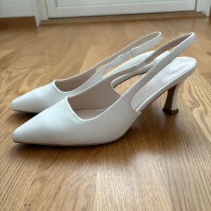 Vita pumps med spetsig tå och klack - Stilrena vita pumps med spetsig tå och öppen häl. Köpta utomlands! Använda en gång! 💞 klack 3 cm 