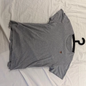 Grå t-shirt från GANT i bomull - Snygg grå t-shirt från GANT i mjuk bomull. Klassisk passform med rund hals och liten broderad logga på bröstet. Perfekt basic-plagg att ha i garderoben.