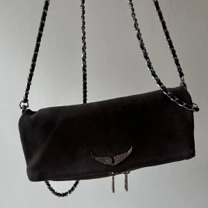 Grå mocka axelväska Zadig & Voltaire - Snygg svart axelväska i mocka från Zadig & Voltaire med kedjerem och silverfärgat märke framtill. Väskan har dragkedja både fram och bak. Perfekt storlek! 