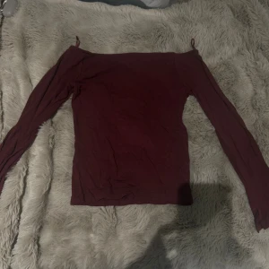 Vinröd offshoulder topp från Cubus - Säljer en vinröd offshoulder topp från Cubus i mjuk bomull. Toppen har långa ärmar och en tight passform som sitter snyggt över axlarna. Perfekt för dig som gillar stilrena och enkla plagg med en twist. Storlek 134/140. Super fin nu till hösten 🥰🥰