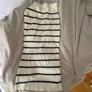 Vit och svart randig stickad långkjol - Säljer en lång, stickad kjol i vitt med svarta ränder💕