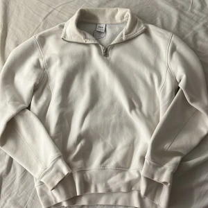 Vit half zip tröja från Zara - Säljer en stilren vit tröja från Zara i storlek S. Tröjan har en hög krage med half zip-dragkedja och är långärmad. Mjuk insida och klassisk passform, perfekt för chill dagar. Materialet är bomull och polyester.