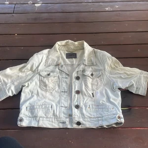 Ljus jeansjacka från ONLY, croppad - Snygg ljusblå croppad jeansjacka från ONLY med korta ärmar och coola detaljer som bröstfickor med lock och knappar framtill. Jackan har dekorativa sömmar och insida med stjärnmönstrade lappar. Perfekt för dig som vill ha en unik denimlook. Strl L på den men passar mig perfekt som är xs/s😁 Använd gärna köp nu❤️