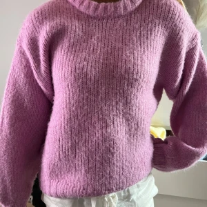 Rosa stickad tröja med rund hals - Supermysig stickad tröja i ljuslila med rund halsringning och långa ärmar. Tröjan har en lite loose passform och ribbade muddar vid ärmslut och nederkant. Perfket till hösten💓