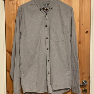 Grå skjorta från WINWIN i bomull - Jag säljer en fin grå skjorta i storlek L från märket WINWIN vilket är Carlings egna märke. Den är endast använd ett fåtal gånger.