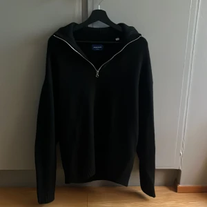 Svart stickad half zip tröja Jack & Jones - Säljer en svart stickad half zip tröja från Jack & Tröjan har en ribbad krage och är långärmad, perfekt för kyligare dagar. Enkel och stilren design som funkar till många outfits. Tröjan är i storlek M men kan även passa L. Den är knappt använd så den är i nyskick.