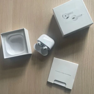 AirPods 4 (ANC) - Apple AirPods 4 med aktiv brusreducering (ANC), modell A3057/A3059. Komplett med originalförpackning och manualer. Hörlurarna och laddningsfodralet ser ut att vara i mycket gott skick, utan synligt slitage. Perfekt för trådlös musik och samtal.