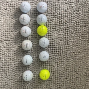 100titlets bollar - Bilden visar flera golfbollar av märket Titleist, både vita och gula. Bollarna ser använda ut med vissa tecken på slitage, men är i överlag gott skick. Perfekt för dig som vill fylla på golfbolls-förrådet till ett bra pris. Inga prov1 eller X 