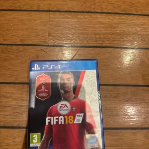 FIFA 18 PS4 - FIFA 18 till PlayStation 4 i fint skick, komplett med fodral, skiva och manual. Innehåller World Cup Russia 2018-uppdatering. Perfekt för fotbollsfans som vill uppleva realistisk spelkänsla och spännande matcher hemma.